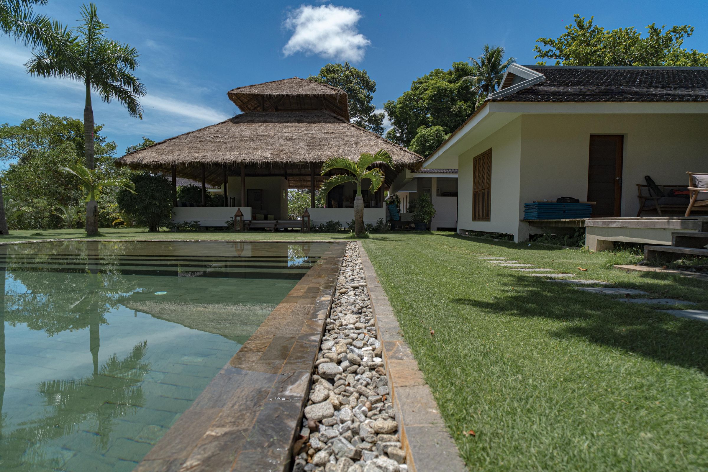Pool and thatched pavilion at Khla Lodge under blue sky